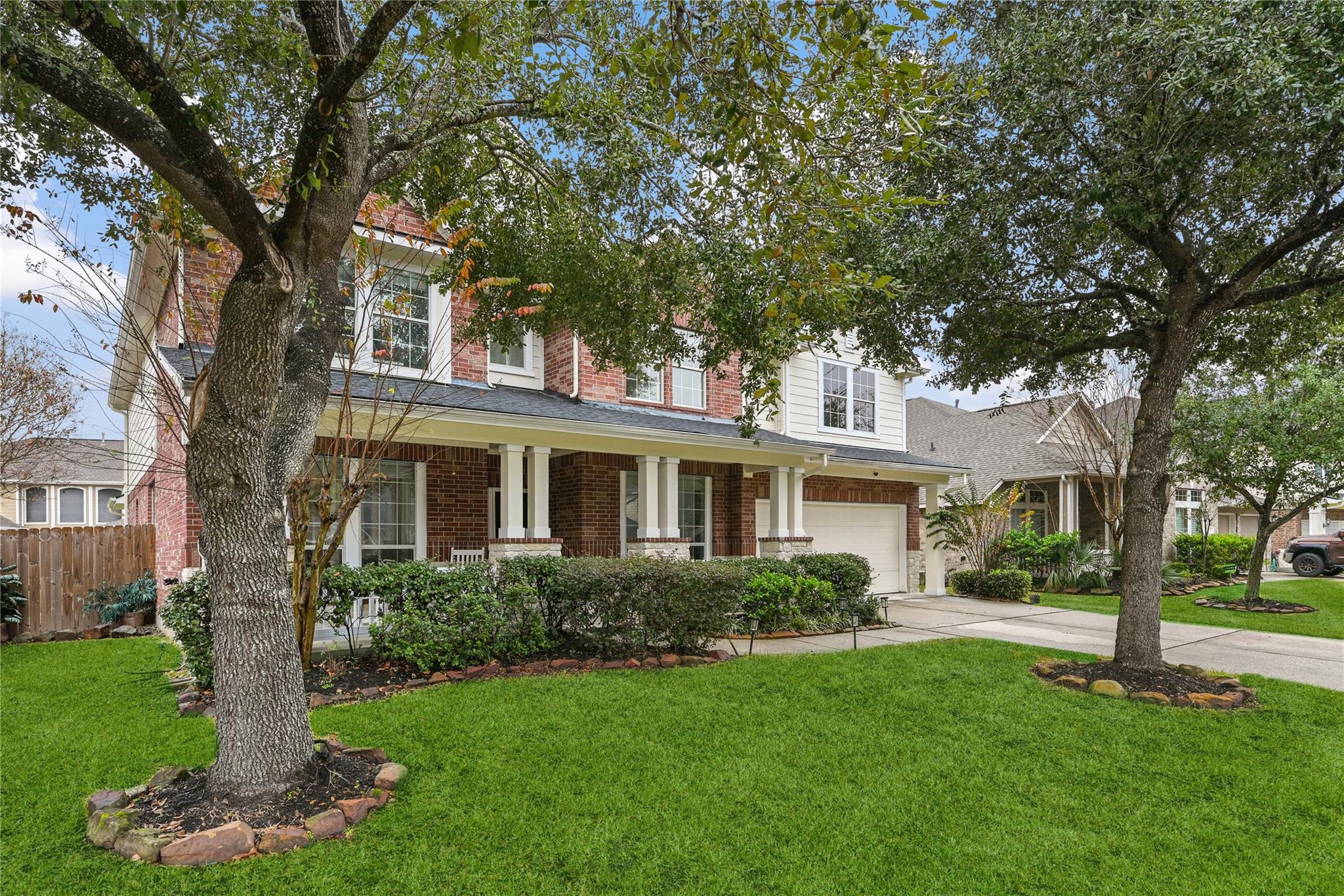 Traditional brick home with shaded front porch in a quiet Houston neighborhood